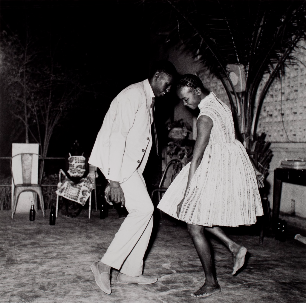 Image: A young man and woman in light clothing dance with one another outside. Malick Sidibé, Nuit de Noël (Happy Club), 1963, printed 2002, Gelatin silver print. Smart Museum of Art, The University of Chicago, Gift of the Estate of Lester and Betty Guttman, 2014.720.