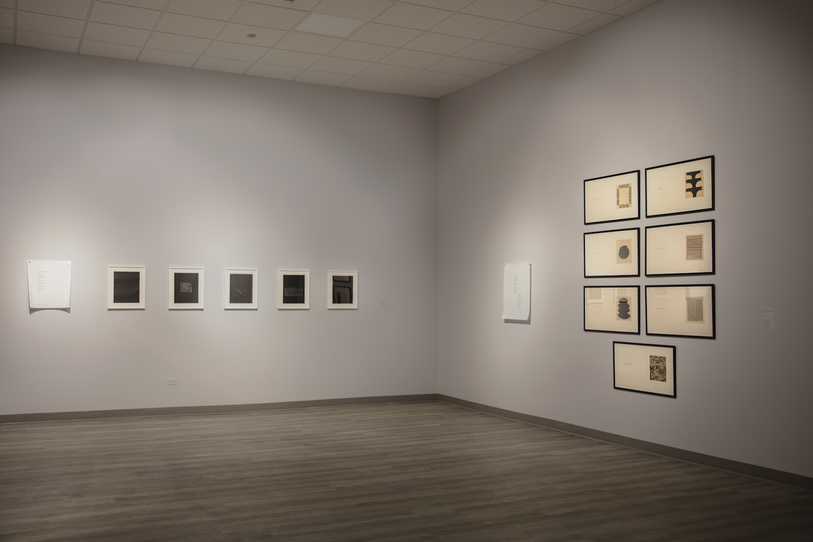 Image: Installation View, Testimonies on Paper, 2023. South Asia Institute, Chicago. A view of two walls in the Testimonies on Paper exhibition. On the left wall, a poem on white paper is positioned to the left of five black etchings. On the right wall, seven etchings with subtitles are placed in a stacked fashion. To their left is a poem on a white paper. Courtesy: South Asia Institute.