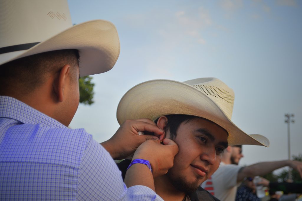 Image: Festival attendee's, Alexis y Mario captured fixing their earring on Miche festival grounds, 2023. Photo by Luz Magdaleno Flores