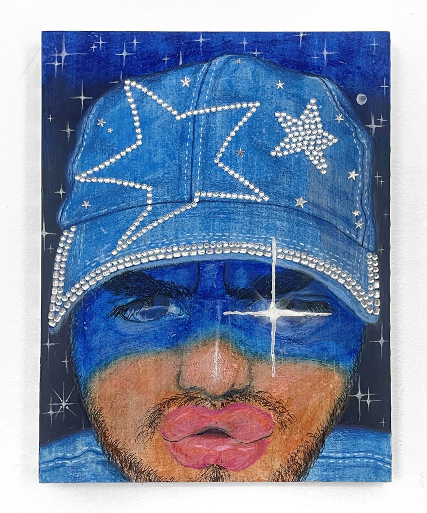 Image: Palacios’s piece Autoretrato con Gorra Empedrada hanging on a white wall. Self portrait embellished with rhinestones. Photo courtesy of the artist. 