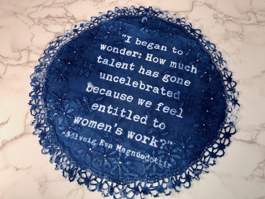Image: Elaine Luther, I began to wonder…., 2022. The white and blue doily which has a crocheted fancy ending, reads: “I began to wonder: How much talent has gone uncelebrated because we feel entitled to women’s work? - Sólveig Eva Magnúsdóttir." Image courtesy of the artist.
