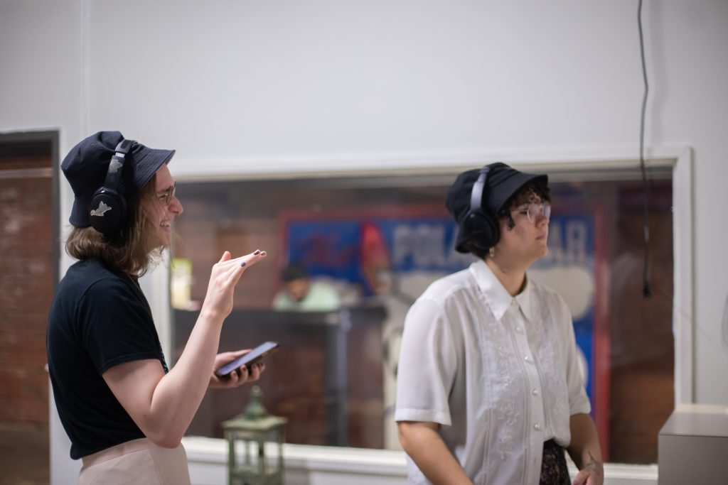 Image: Two people are listening to new sound collaborations created by Peoria-based musicians in collaboration with the visual artists for this exhibition. Photo by Alexa Cary.