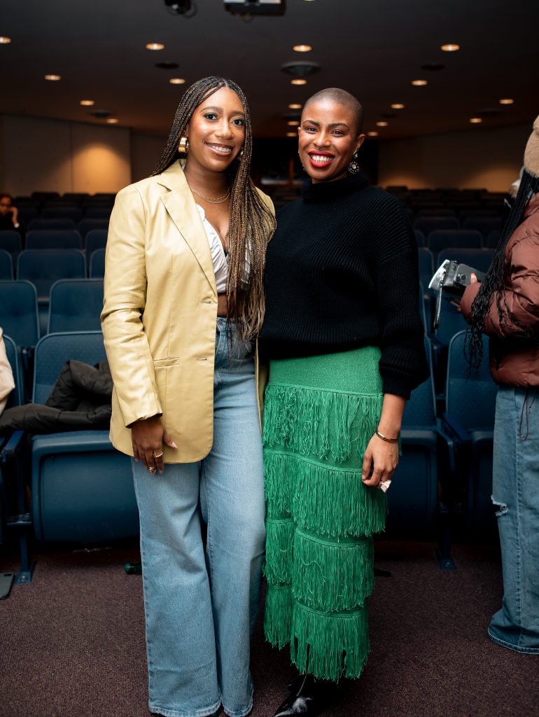 Image: Redmond and Wholley standing next to each other and smiling broadly following the film screening. Behind them are rows of blue theater seats. Photo by Nick Moody.