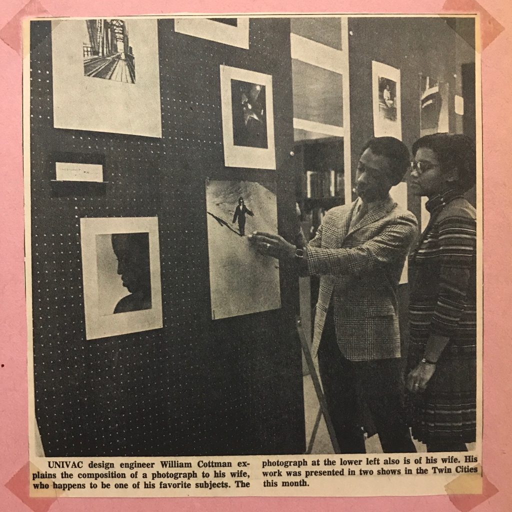 Image: Newspaper clipping of William Cottman showing one of his photographs hung on the wall to his wife, Beverly, who stands besides him. Photo courtesy of writer.