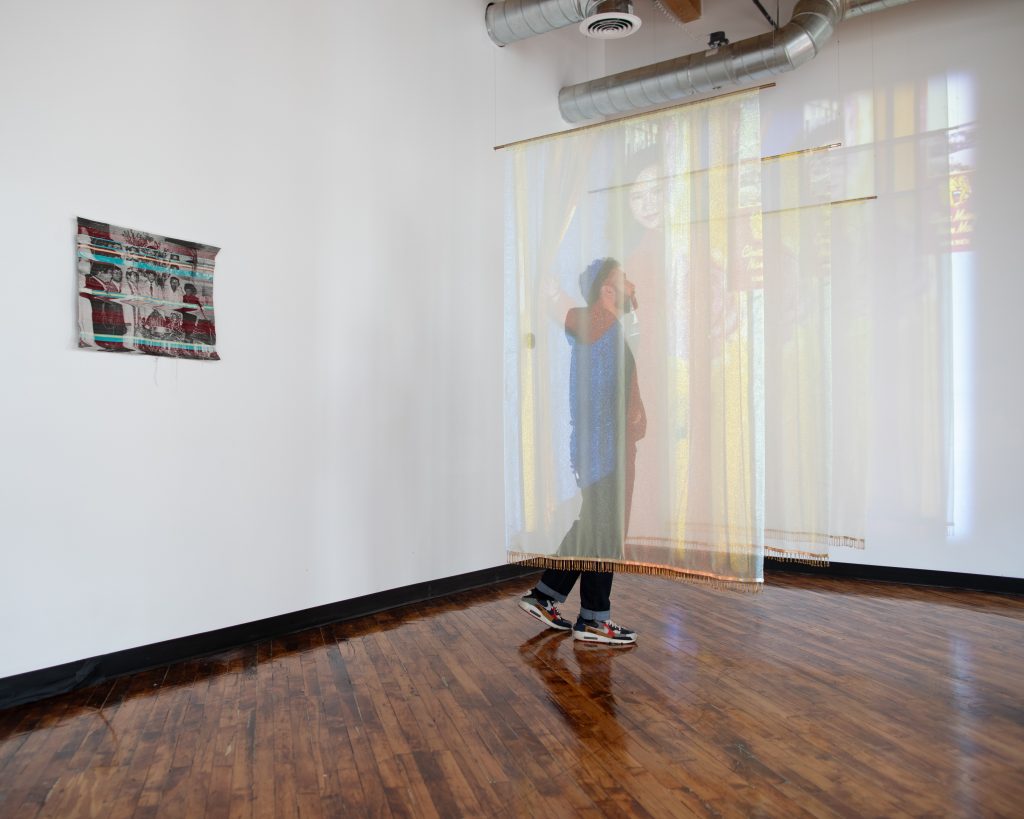 Image: A guest walking in between Trần’s "Offerings" installation. Photo by Khalid Ibrahim.