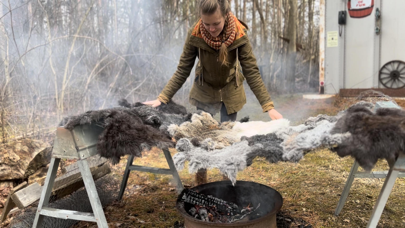 Image: Debbie Christensen, a member of Rust Belt Fibershed, tanning local hides over a fire outdoors. Photo Courtesy of Corinne Wiseman.