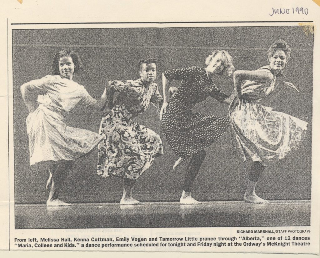 Image: Four girls in dresses perform a synchronized routine onstage in a newspaper clipping from the 90s. Newspaper cutout of Kenna Cottman in a performance with high school peers circa 1990. Photo courtesy of writer.