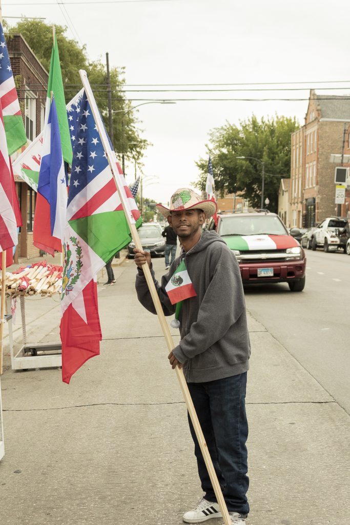 Imagen: Un hombre sonrie deteniendo una bandera que es mitad bandera Mexicana y Americana. Foto x Cobalto es azul, 2023.