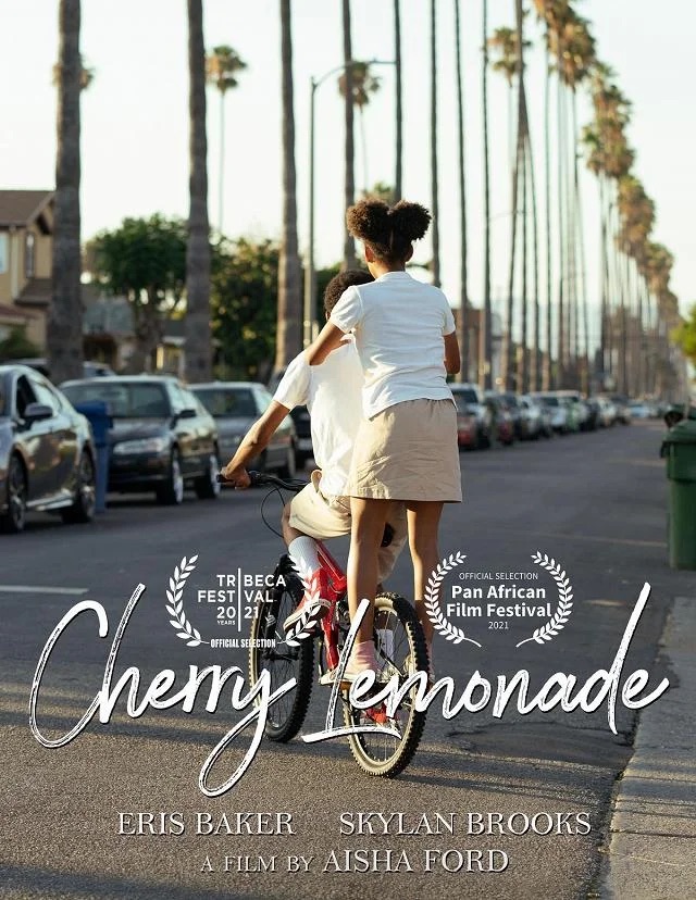 Image: Publicity poster for Cherry Lemonade. Two Black kids, one riding a bike, the other standing on the back pegs, facing a long as[halt stretch with tall palm trees running down its side. On the same side, cars parked parallel.  On the bottom of the image is "Cherry Lemonade" in cursive. Image courtesy of Aisha Ford.