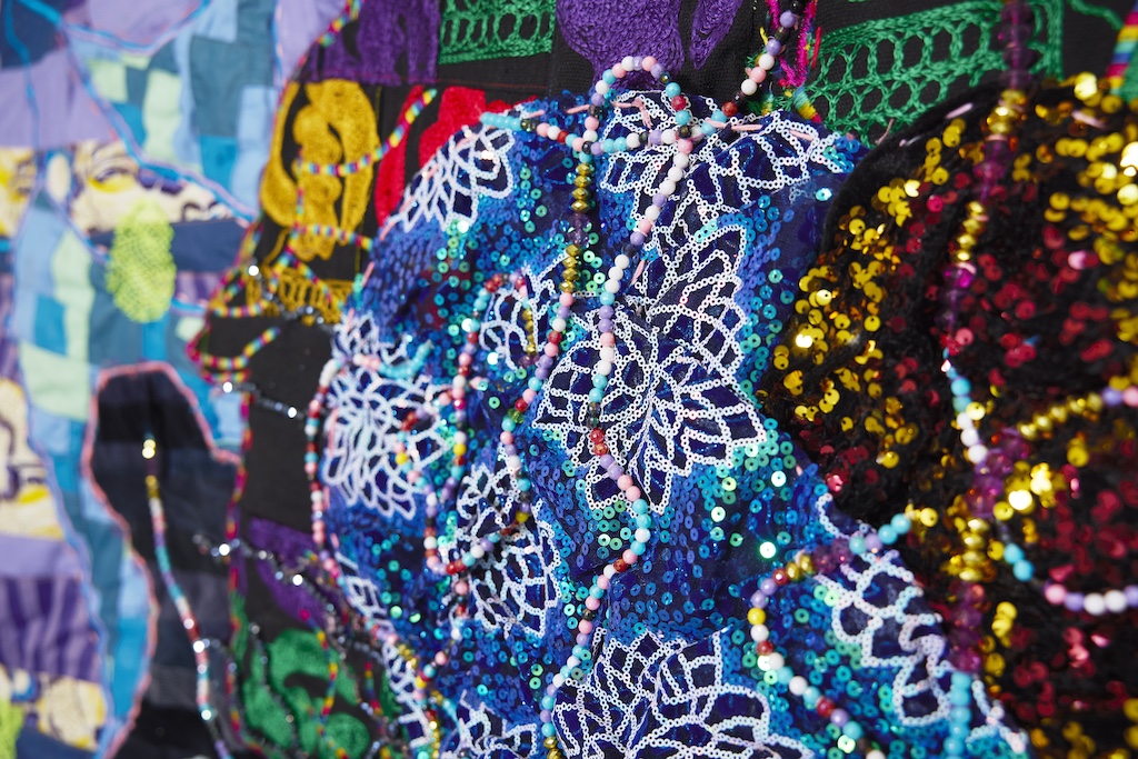 Image: Great Rivers Biennial 2024: Basil Kincaid, installation view, Contemporary Art Museum St. Louis, September 6, 2024–February 9, 2025. A close up view of a large textile piece showing details of beads, sequins, and embroidery. Photo by Izaiah Johnson.