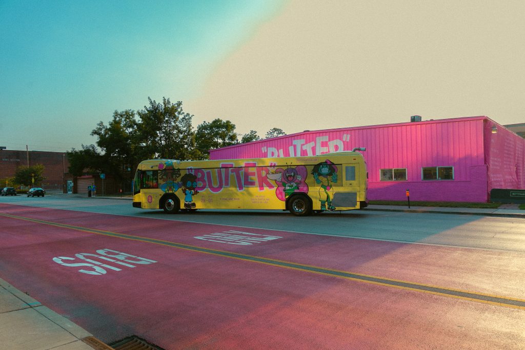 Image: A city bus wrapped in the BUTTER branding parked in front of a pink BUTTER branded building in Indianapolis. Image courtesy of GANGGANG.