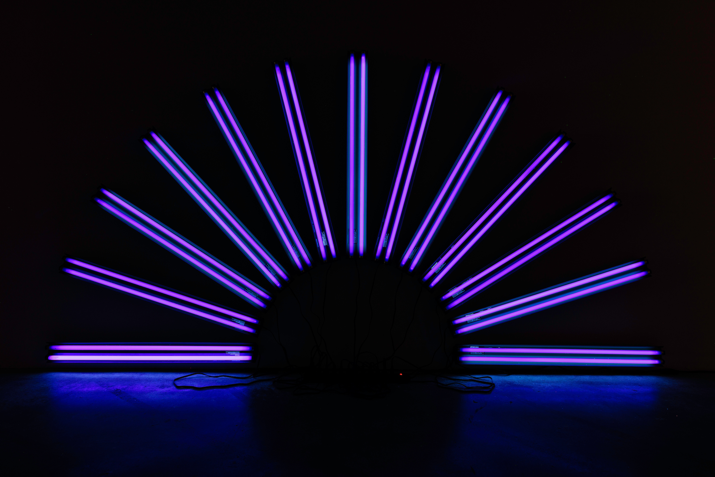 Image: An installation view of “Black Suns”, by Paul Stephen Benjamin, which consists of LED lights lit like sun beams from a black sun on a dark night. Photo by Colin Conces, courtesy of Bemis Center.