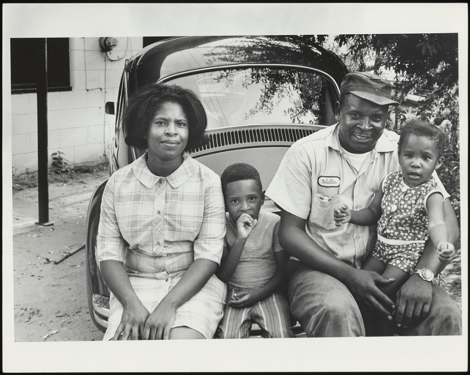 Image: Black-and-white photo of unidentified parents sitting with their two young children on the bumper of their car in Montgomery, AL, 1971. Photograph by Moneta Sleet Jr., Johnson Publishing Company Archive. Courtesy J. Paul Getty Trust and Smithsonian National Museum of African American History and Culture.