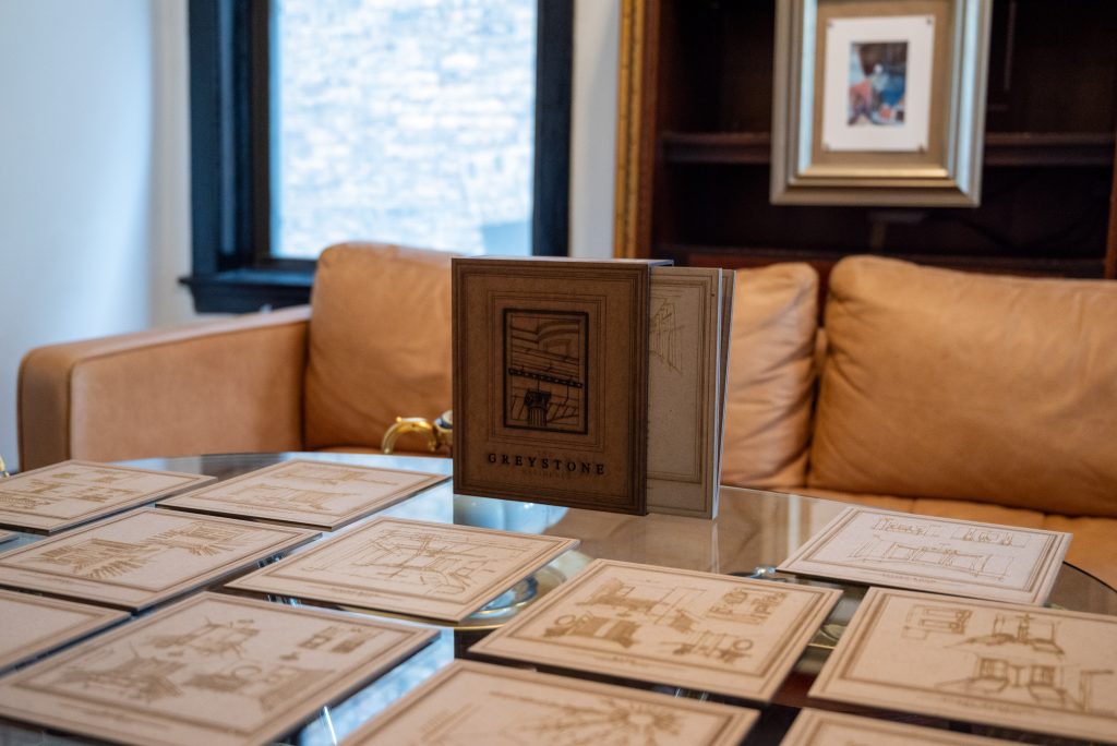 Image: A close-up shot of glass table with prototypes of various imagined rooms in the Greystone. Photography by Tonal Simmons.