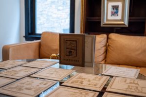 Image: A close-up shot of glass table with prototypes of various imagined rooms in the Greystone. Photography by Tonal Simmons.