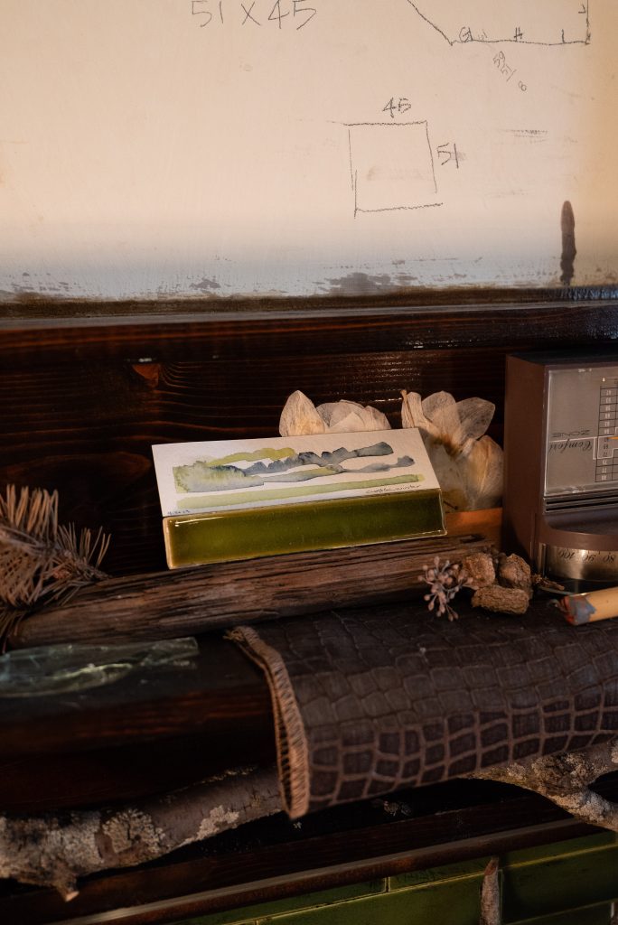 Left Image: Detail shot of a wood mantel with dried herbs, scraps of fabric, and art objects. Photography by Tonal Simmons.