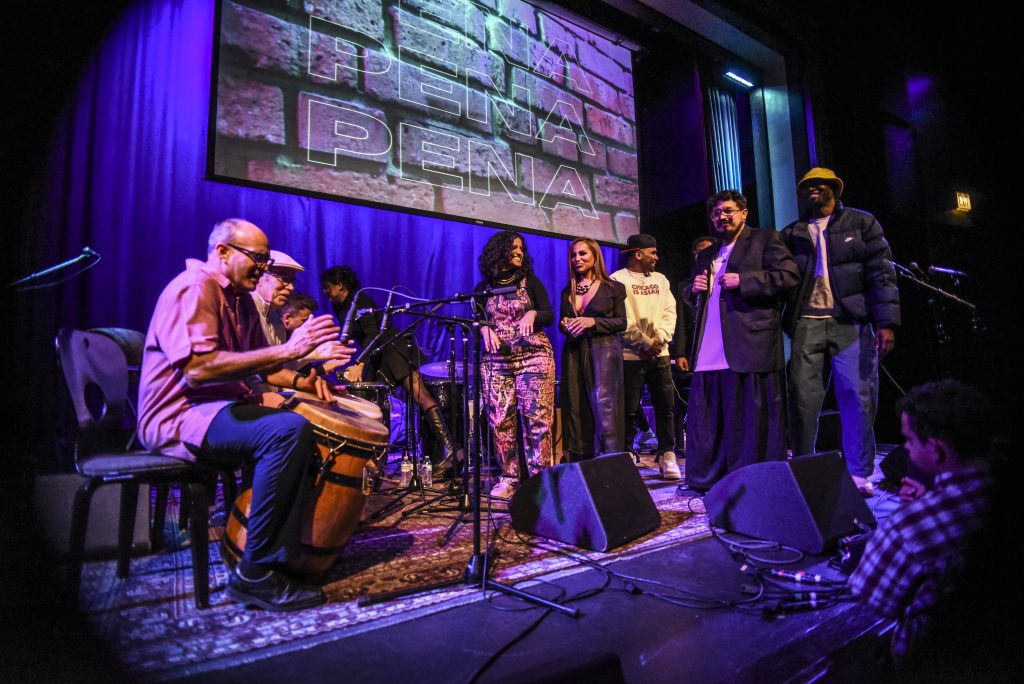 Image: Foto of Lester Rey joining all the evening’s performers on stage at Old Town School of Folk Music and celebrating Africaribe—a nonprofit dedicated to preserving, researching, promoting, and developing Puerto Rican and Caribbean cultures. Digital foto by Carolina Sánchez. 