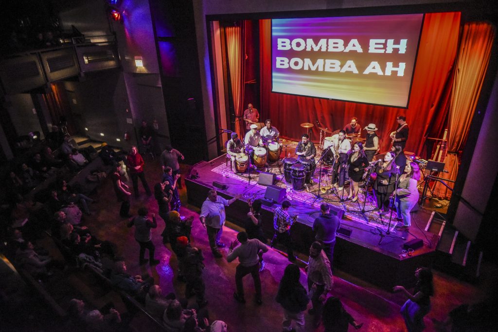 Image: Foto captured an aerial view of the auditorium during intermission, Africaribe energized the audience with a powerful performance of Lester Rey’s song "Bomba," setting the stage for the second half of the show. Digital foto by Carolina Sánchez.