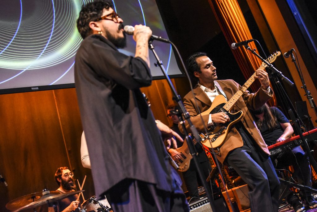 Image: Foto of Lester performing with local Latin artist Gabacho who made a special guest appearance, blending surf rock and Latin rhythms on an unreleased song with Lester Rey. Digital foto by Carolina Sánchez.