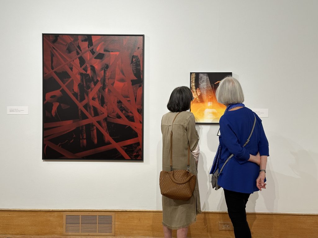 Image: A photograph of two visitors standing and viewing two archival inkjet prints from the exhibition. Image courtesy of the Des Moines Art Center. 