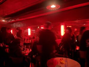 Image: A red light glows over a crowd that gathers at Dorothy Carlos' album release ambiance at the California Clipper in Chicago. Image courtesy of Nadia John.