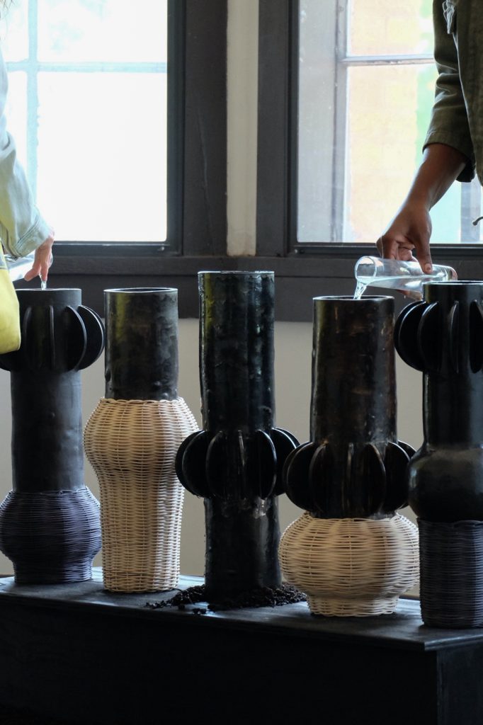 Images: ebere agwuncha, nsude 1-5 featured in owoko at Comfort Station, 2022. Documentation of ebere and a visitor participating in the water pouring ritual with select owoko vessels. Photo credit: B. Sanborn.