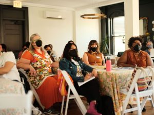 Image: A group of writers and editors sit and listen to a presentation at Sixty's Midwest Arts Writers Convening. The event took place at Haymarket House from April 27-29, 2025. Image made by Seed Lynn (@seedlyn).