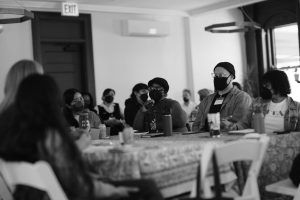 Image: A group of writers and editors sit at a table discussing the needs of our communities at Sixty's Midwest Arts Writers Convening. The event took place at Haymarket House from April 27-29, 2025. Image made by Seed Lynn (@seedlyn).
