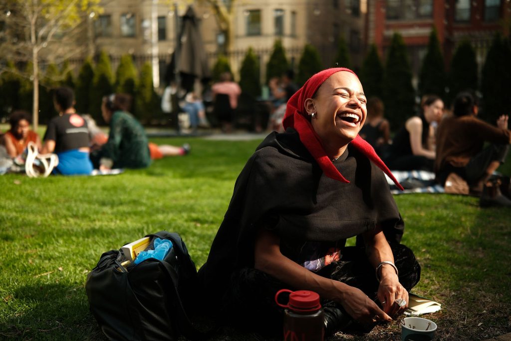 Image: Camille Bacon, co-Founder and editor-in-chief of Jupiter Magazine, laughs and smiles while dialoguing with other arts writers on the Haymarket House Lawn. Image made by Seed Lynn (@seedlynn).