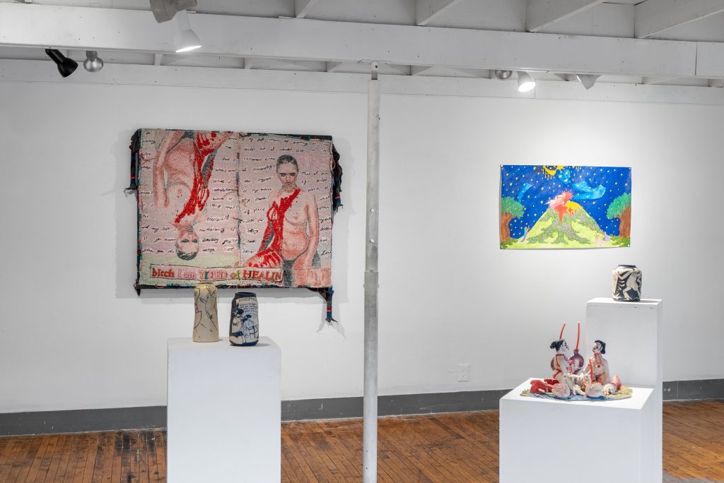 Image: Installation View, Eden Through a Glory Hole, 2025, Chicago Art Department. Vessels and bodies intertwined in sculpture are on three pedestals framing a large textile of a bleeding body and a saturated landscape. Photo: Mikey Mosher. Courtesy of Tali Halpern.