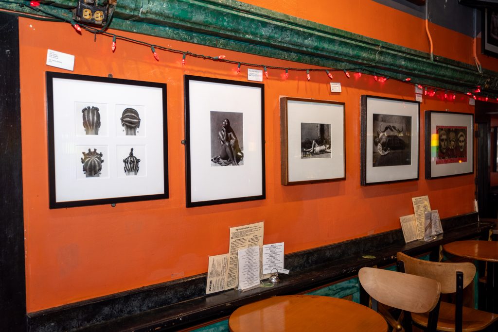 Image: (1-6, above) Fire’s art collection continues to adorn the walls. Various framed art hang on the walls at Big Chicks. Some walls are orange, some green, and some pale yellow. Images by Tonal Simmons.