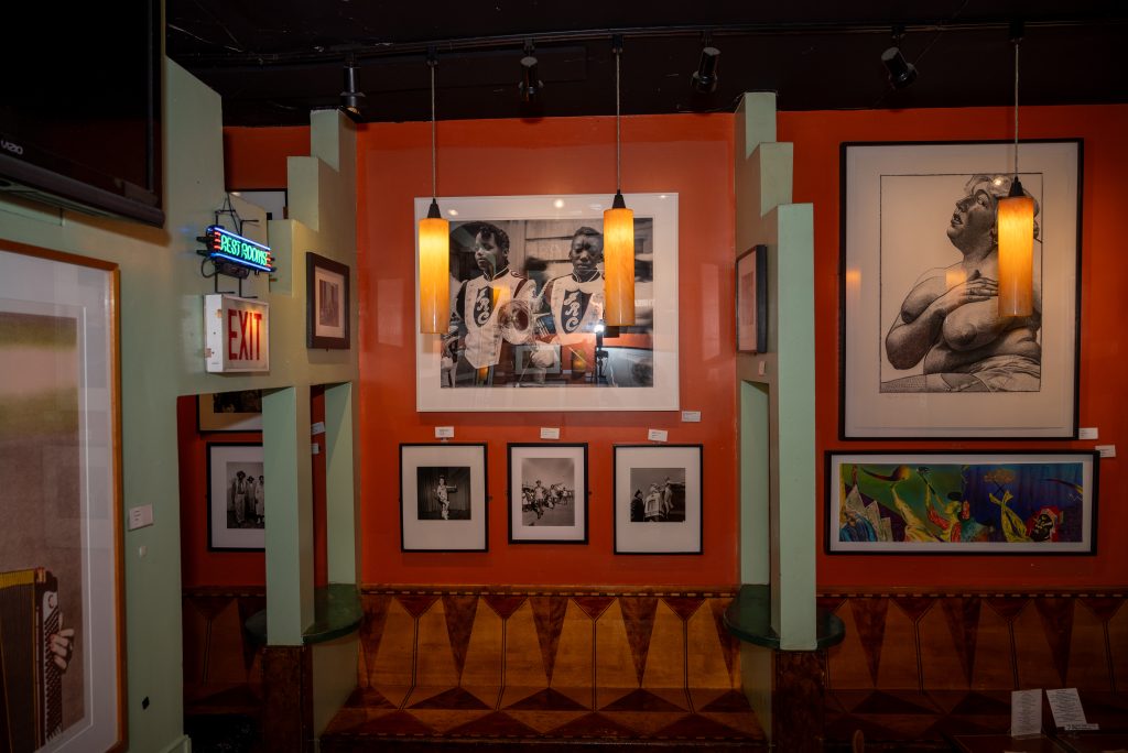 Image: (1-6, above) Fire’s art collection continues to adorn the walls. Various framed art hang on the walls at Big Chicks. Some walls are orange, some green, and some pale yellow. Images by Tonal Simmons.