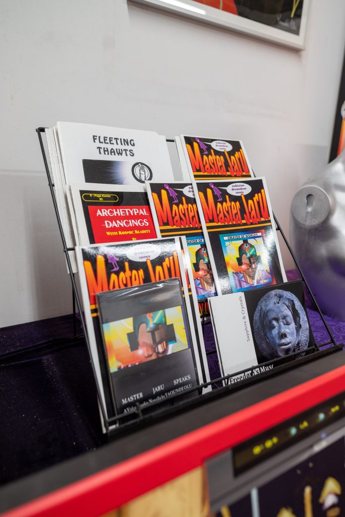 Image: Master Jaru. Fleeting Thawts Archtypal Dancing, a brochure for Sapphires and Diamonds and other works by Yaounde are on display on a table in ehr studio. Image by Tonal SImmons.