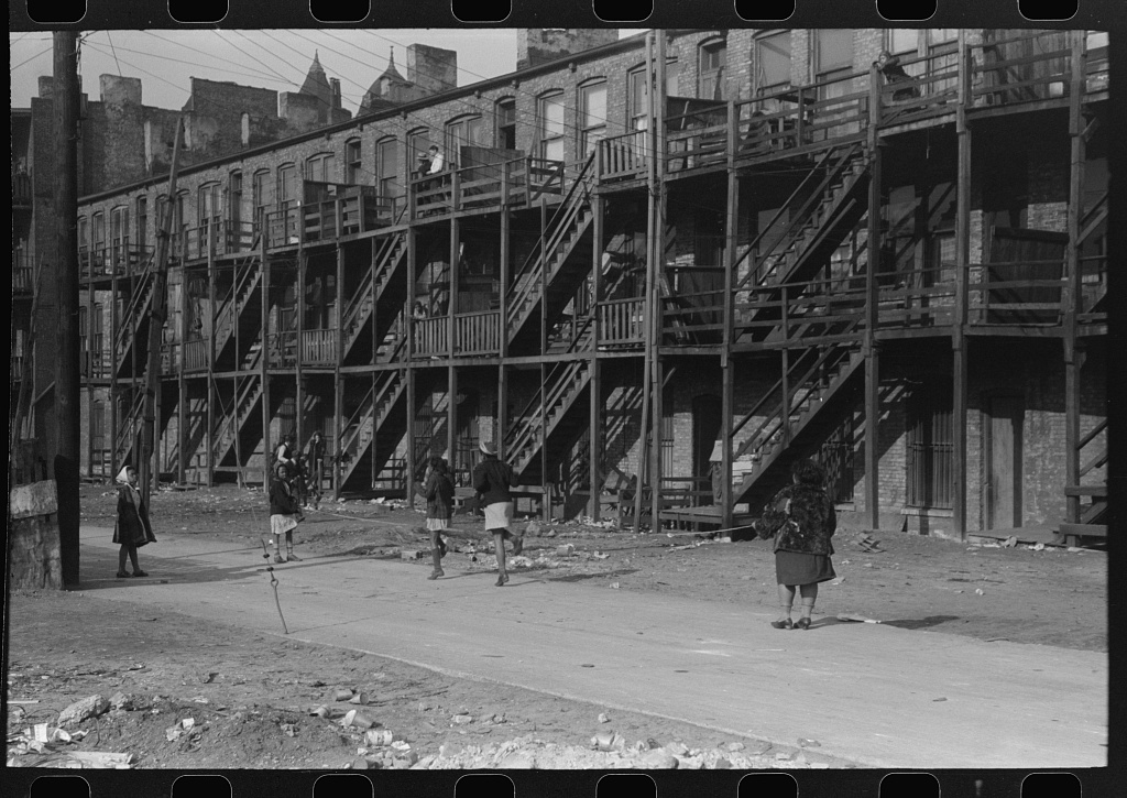 Image: Apartment building in a Black Belt section of Chicago, Illinois taken in April, 1941. Young girls play jump rope behind the building. Image by Russell Lee. Gelatin-silver print. FSA-OWI Collection, Prints and Photographs Division, Library of Congress.