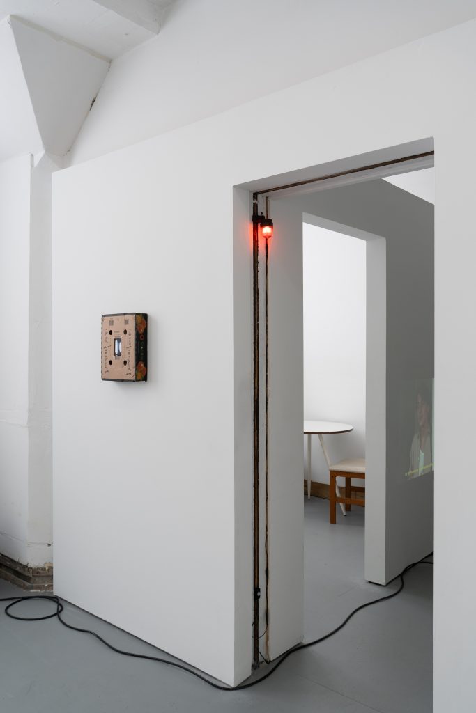 Image: Installation view of the exhibition showing two gallery doorways. Artworks in view include Speech Assistance Machine (Leonard Cohen’s Democracy, 1992) and A Thousand Telephones (scenes 1-5). Image courtesy of Letters to Nora.