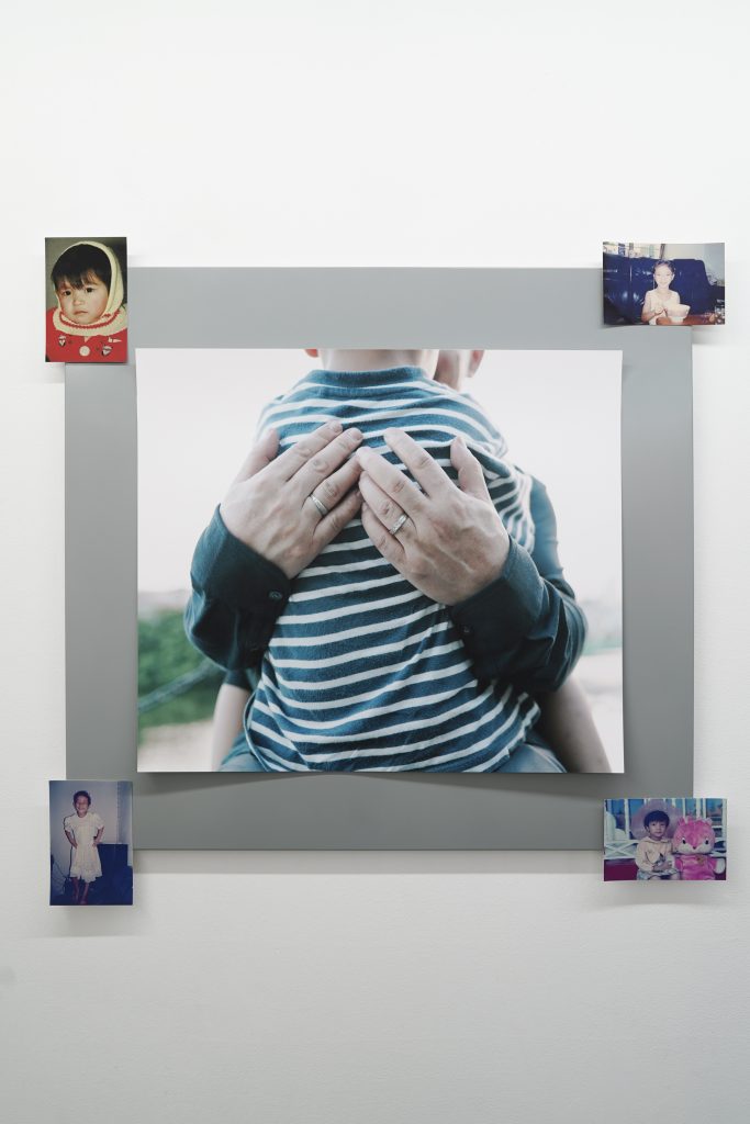 江麟冶作品《顺顺与父亲》（2019）展览现场。作品为喷墨打印，并以磁条固定于金属板上。展出同时包含四张家庭档案照片（4 × 6 英寸，2025 年再版），影像内容为艺术家 1988 至 1996 年的童年时期。照片由艺术家提供。