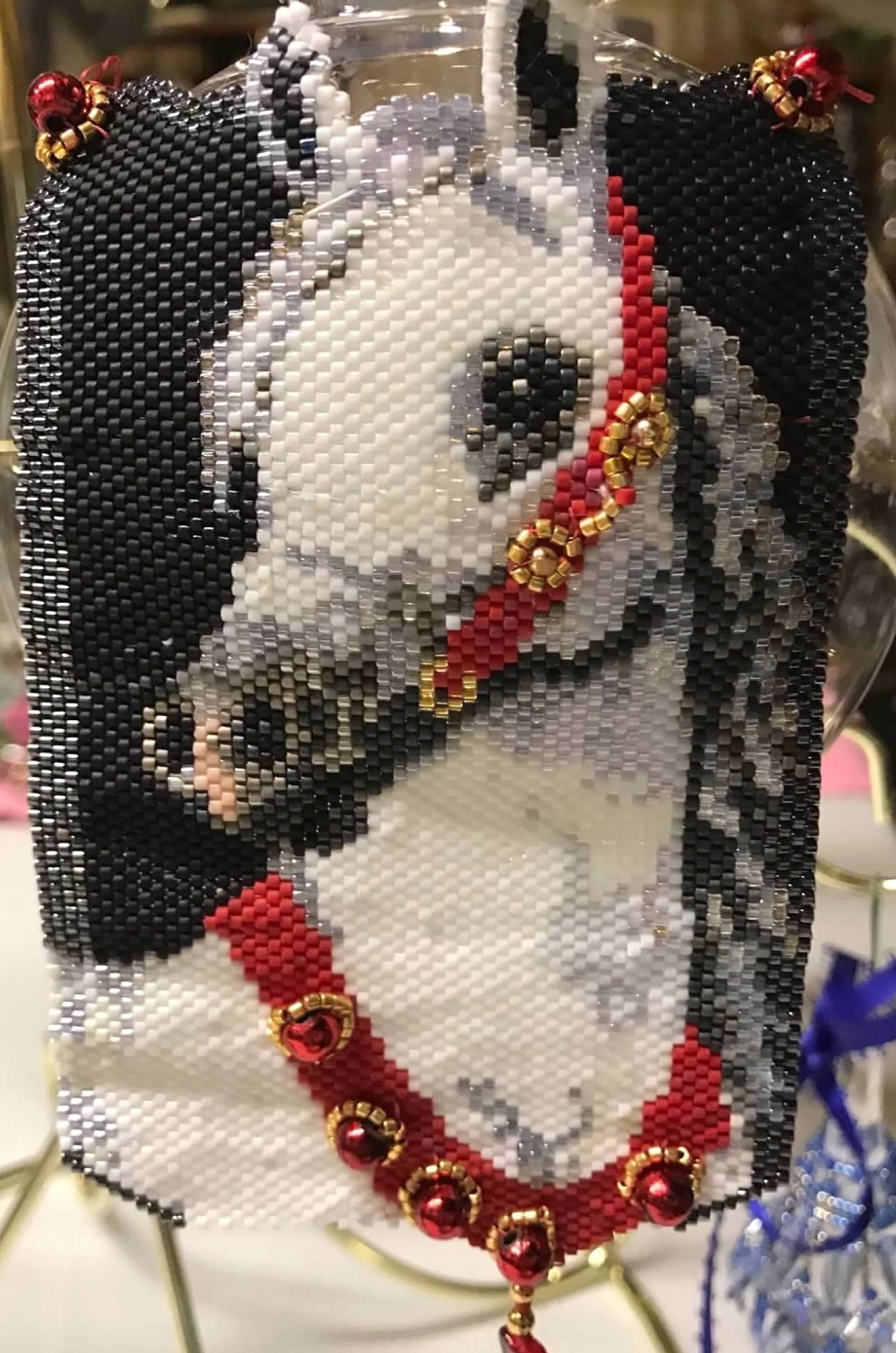 Photograph of a beaded ornament depicting a white horse with red and golden stirrups. Image courtesy of Veronica Kirin.