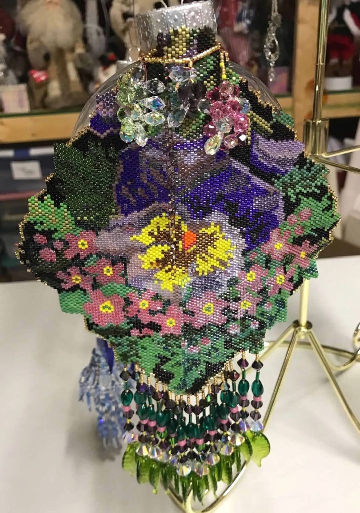 Photograph of a beaded ornament depicting a floral design created by Grace Stinton. Image courtesy of Veronica Kirin.