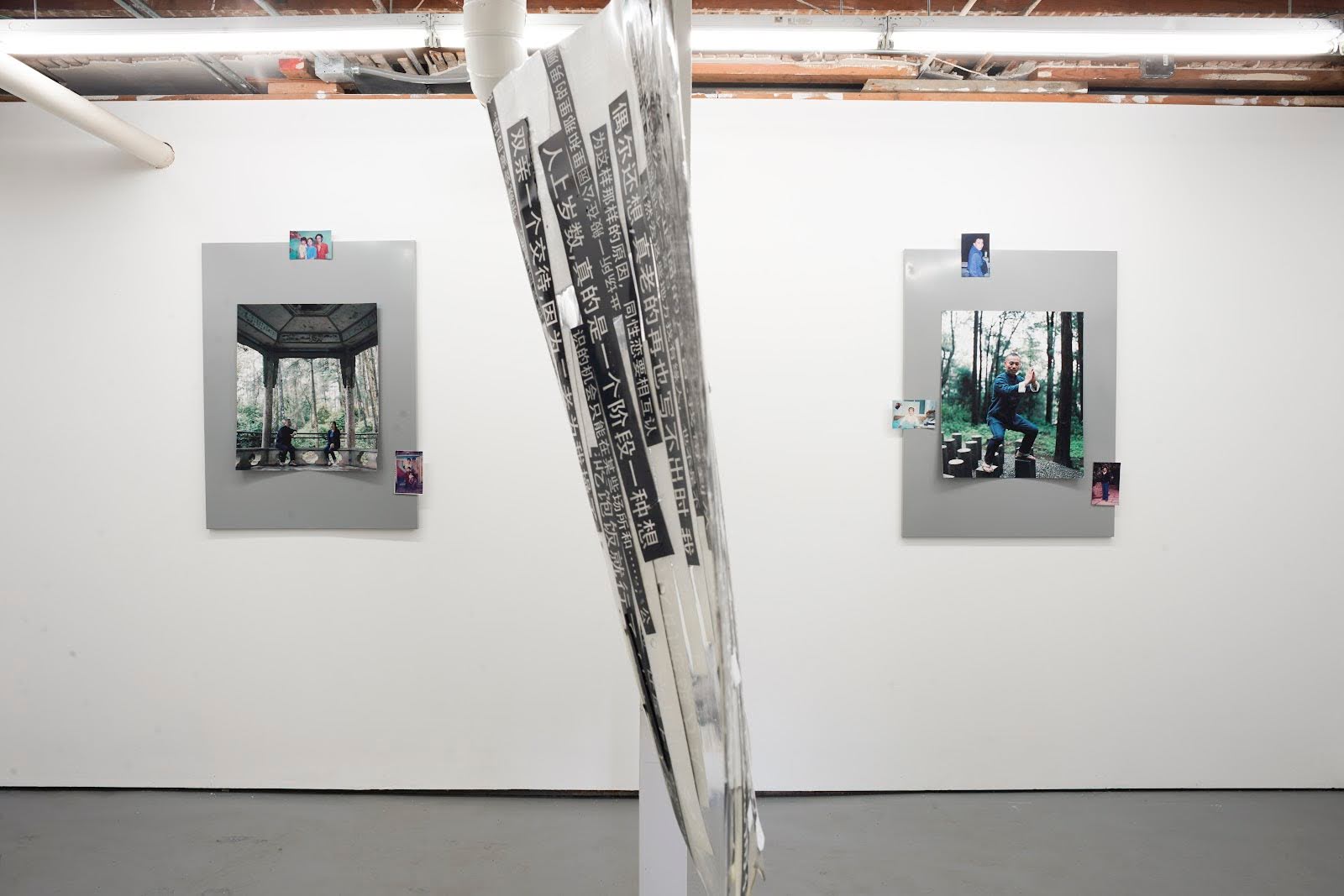 江麟冶《Scavenger Hunt》展览现场一景。展厅中央悬挂的是雕塑作品《摘录自父亲小说〈深圳故事〉》，由父亲书写的文字片段构成。左墙为作品《父母》（2018）；右墙为作品《父亲》（2018）。两件作品均为喷墨打印，并以磁条固定于金属板上。照片由艺术家提供。