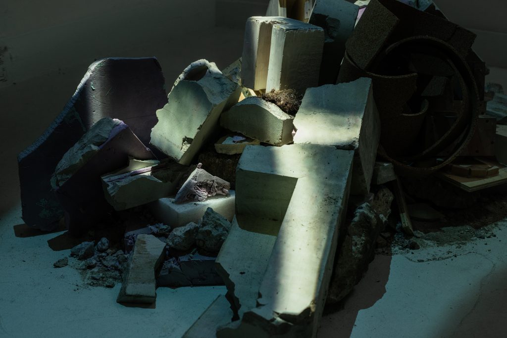 A pile of rubble is illuminated by a band of light. 