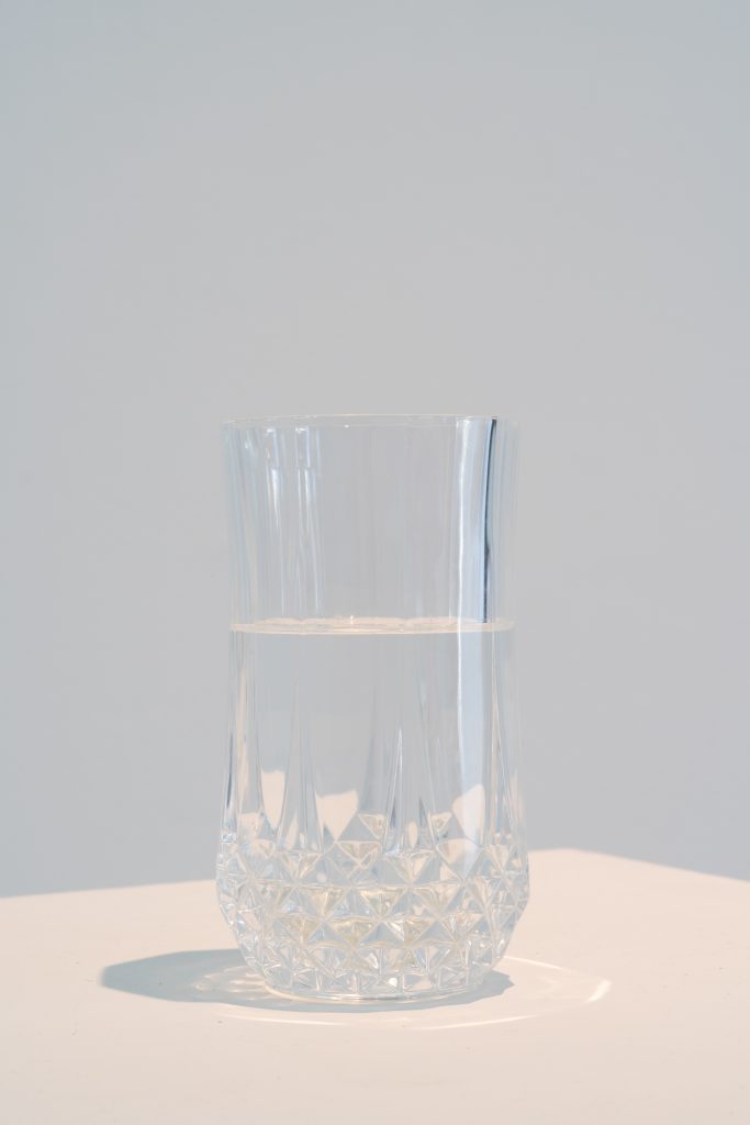 Kitty Rauth, Unsinkable, (2025). A crystal class filled with glacier water is presented atop a plinth. Photo by Jonas Mueller-Ahlheim.