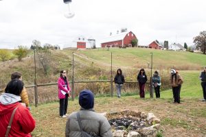 Savannah Sanctuary in Dodgeville, WI. All the participants pictured surrounding a fire pit for a workshop led by Teddy Sandler. Behind them is the barn and silo. Photo by and courtesy of Max Li.