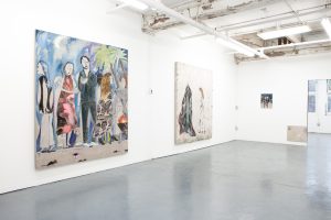 Installation view, Mari Eastman: Studio Simulacrum, Goldfinch, 2017. This was the first show of the gallery. Three paintings hang on the white gallery walls. The two paintings closest to the viewer are large, nearly floor-to-ceiling pieces, that feature figures standing together against a deep blue-purple night sky. The third painting is small and hangs on the farthest wall, it is hard to see the two figures standing against a dark blue background. Courtesy of Goldfinch.