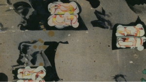 Detail of a mixed-media artwork by Jess Zottola. Abstract white, orange, and yellow shapes and bold black shapes dot a grey background. Courtesy of Glass Breakfast.