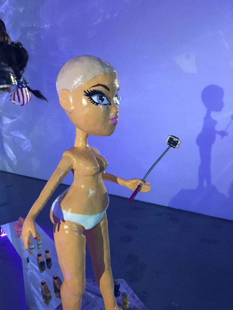 Installation view, Mia Ardito and Máire Witt O’Neill, Sad Girls Club TV, 2017. Mixed media sculpture in the form of a hairless Bratz doll carrying a selfie stick. Photo by Claudine Isé. Courtesy of Goldfinch