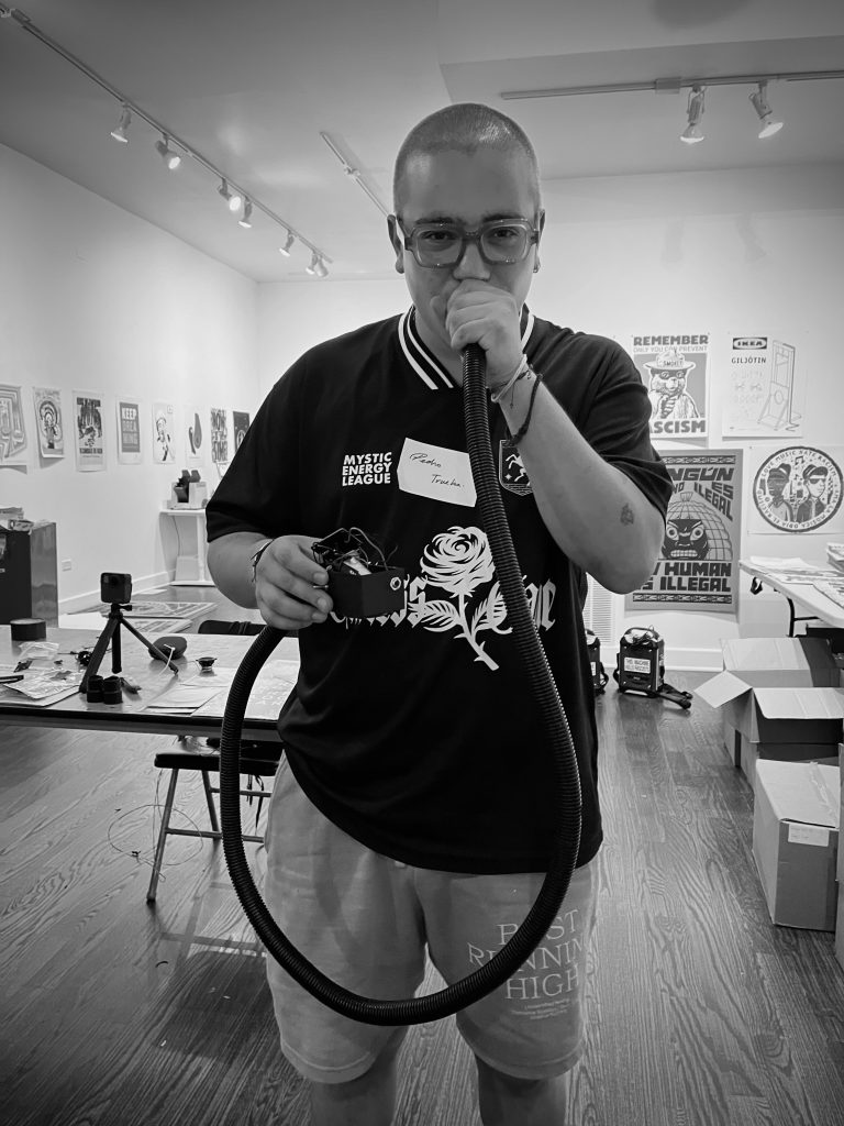 Dos fotografias en blanco y negro de participantes del taller VOZU con su instrumento, Cortesia de Co-Prosperity.