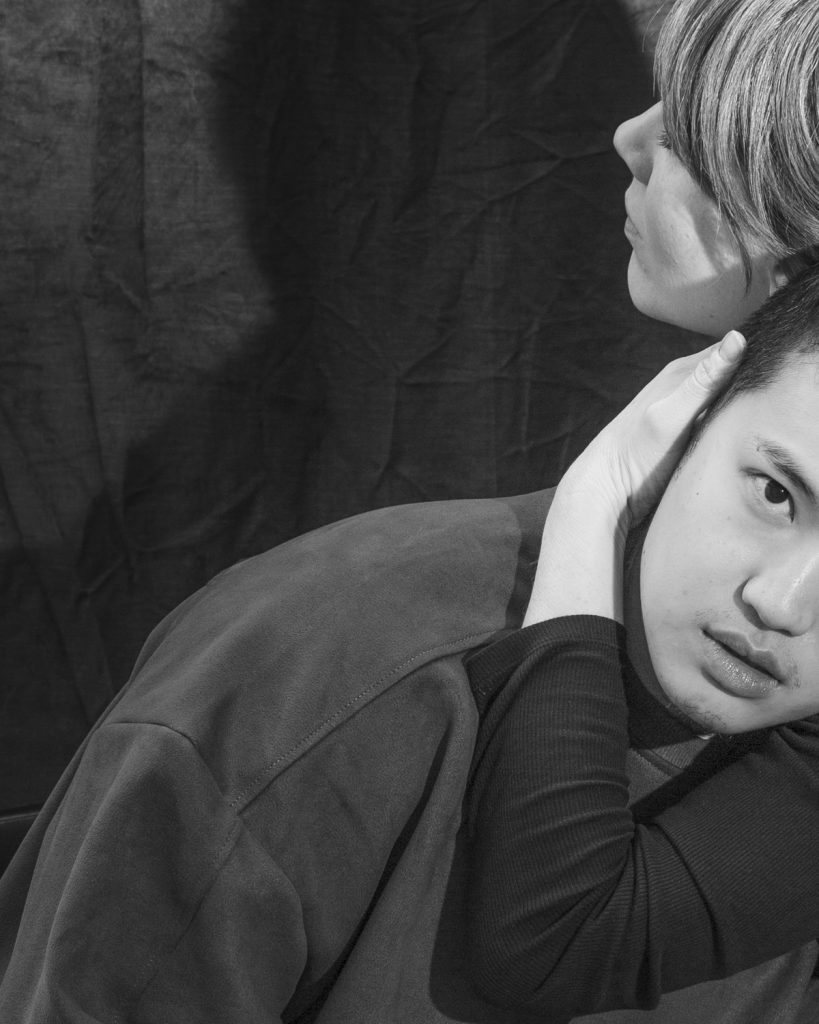 A black and white photograph of two people wrapping their arms around each other from the series Mother Figure by Kat Bawden, 2025.