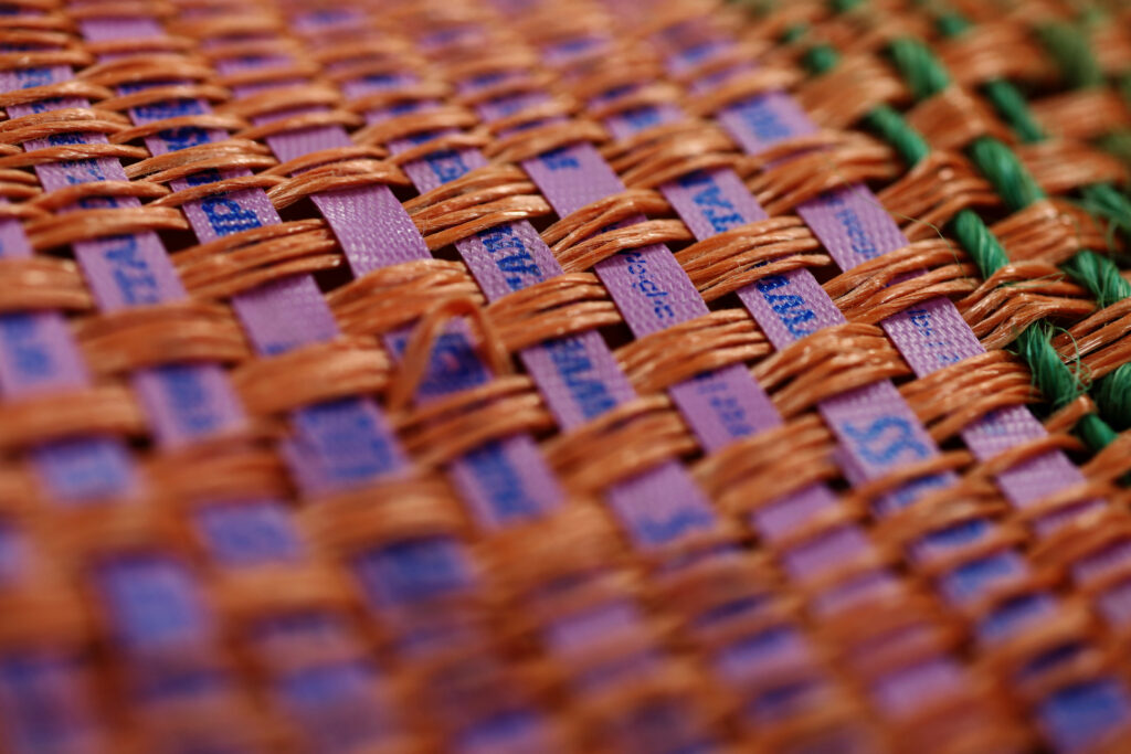 A close-up of the baling twine piece that features lavender plastic cinch cords from Timothy hay bales striped between dyed sisal that was on many larger square bales for the sheep and goats. Image by Viki Stark.
