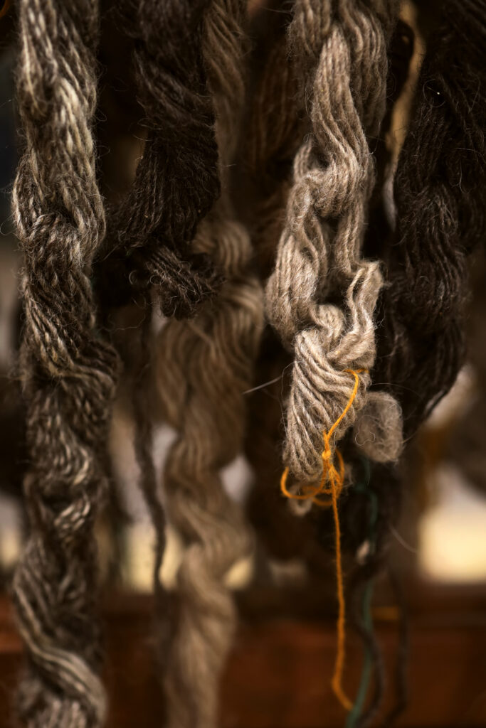 A close-up photo of brown and cream colored yarn, neatly woven, draping downwards. Image by Viki Stark.
