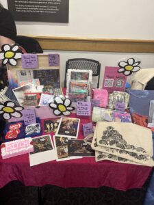 A photo of LaDasia Bryant's vending table at Milwaukee Zinefest. Table features stickers, tote bags, zines, riso prints, postcards, and more for the festival attendee to touch and buy. Photo courtesy of the author.